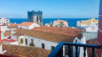 Un paisaje urbano costero con una torre destacada y edificios con tejados de teja.