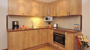 Una cucina con mobili in legno, un forno a microonde, una macchina da caffè e un tostapane.