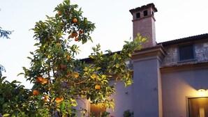 A building with a stone facade, a brick chimney, and a well-lit entrance. - Agriturismo Il Convento (Massa Lubrense)