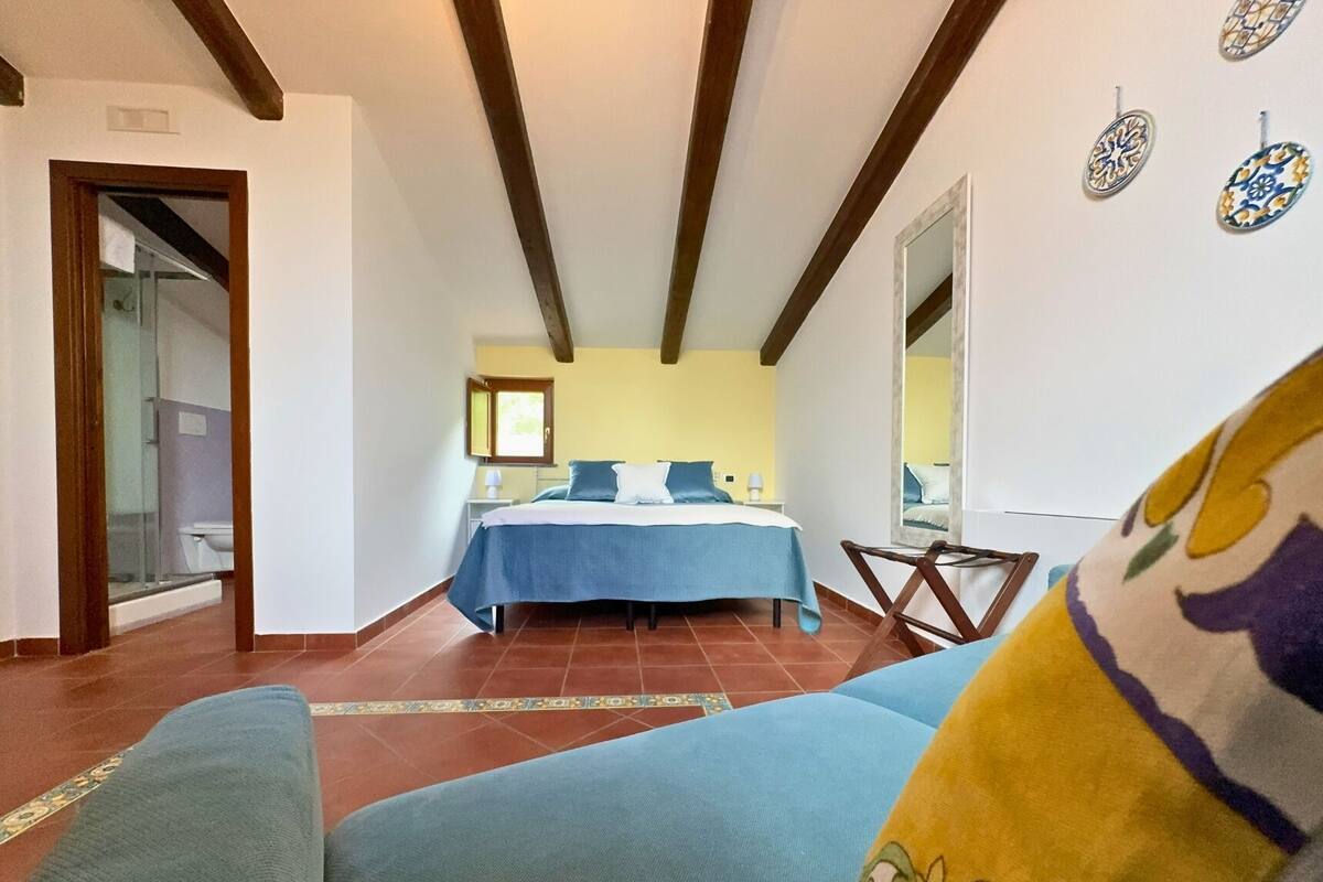 Ein Schlafzimmer mit einem Bett, einem Sessel und einem Fenster.