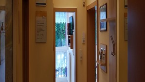 A hallway with a ceiling light fixture, a door leading to a balcony, and a sign on the wall. - sonnige, ruhige, zentrale Ferienwohnung mit Bergblick am Rupertuspark (Bad Reichenhall)