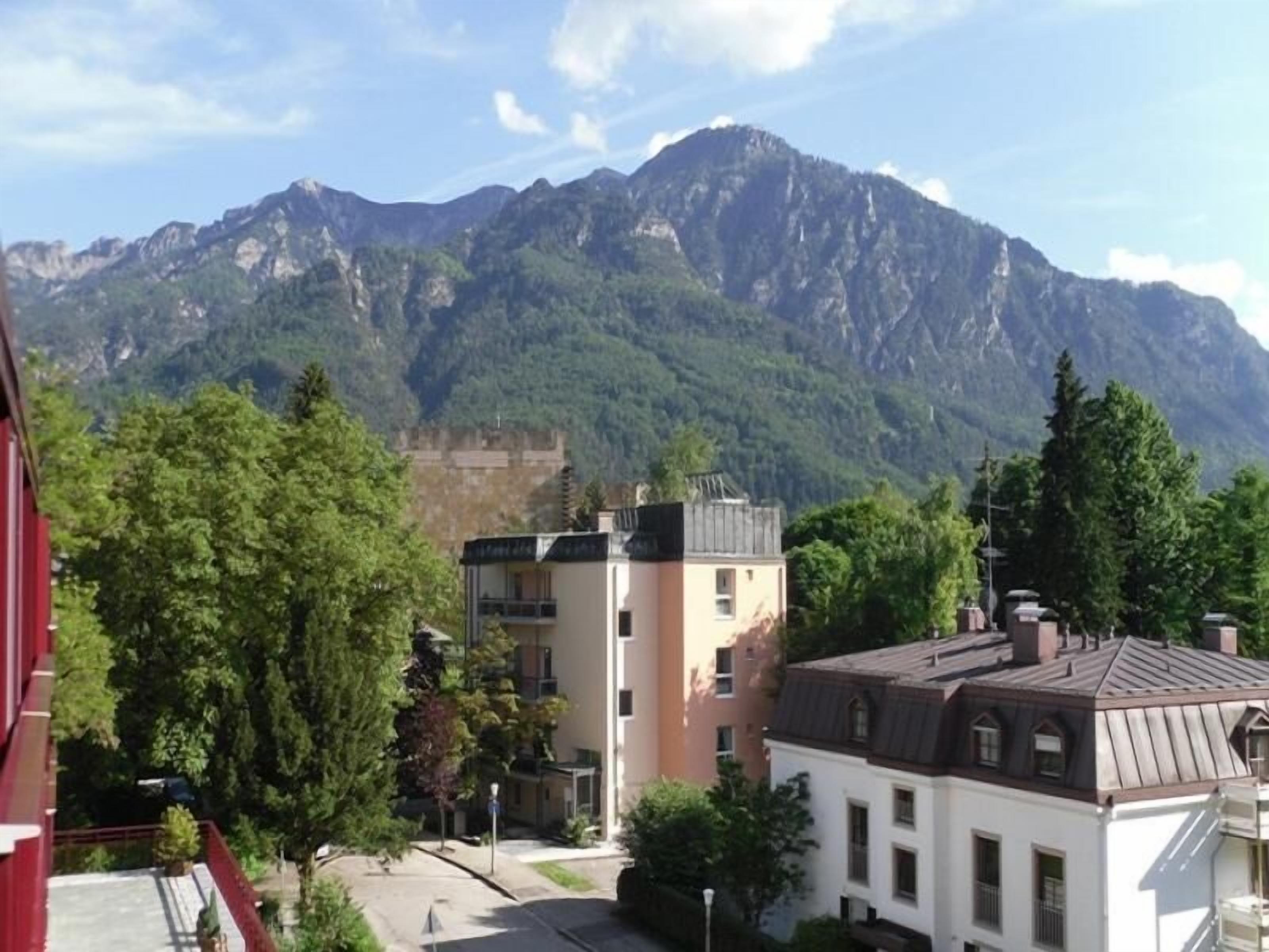 Un quartier résidentiel avec des immeubles et une chaîne de montagnes en arrière-plan.