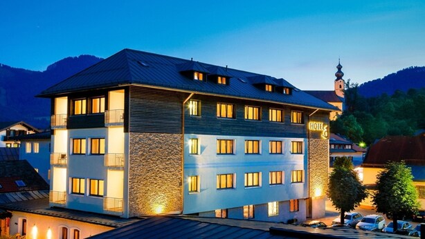 Ein mehrstöckiges Hotel mit Stein-Fassade, mehreren Balkonen und einem deutlich sichtbaren Hinweisschild, das es als Hotel kennzeichnet.