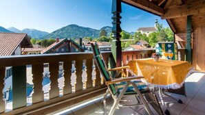 Ein Holzbalkon mit Blick auf Berge und Häuser.