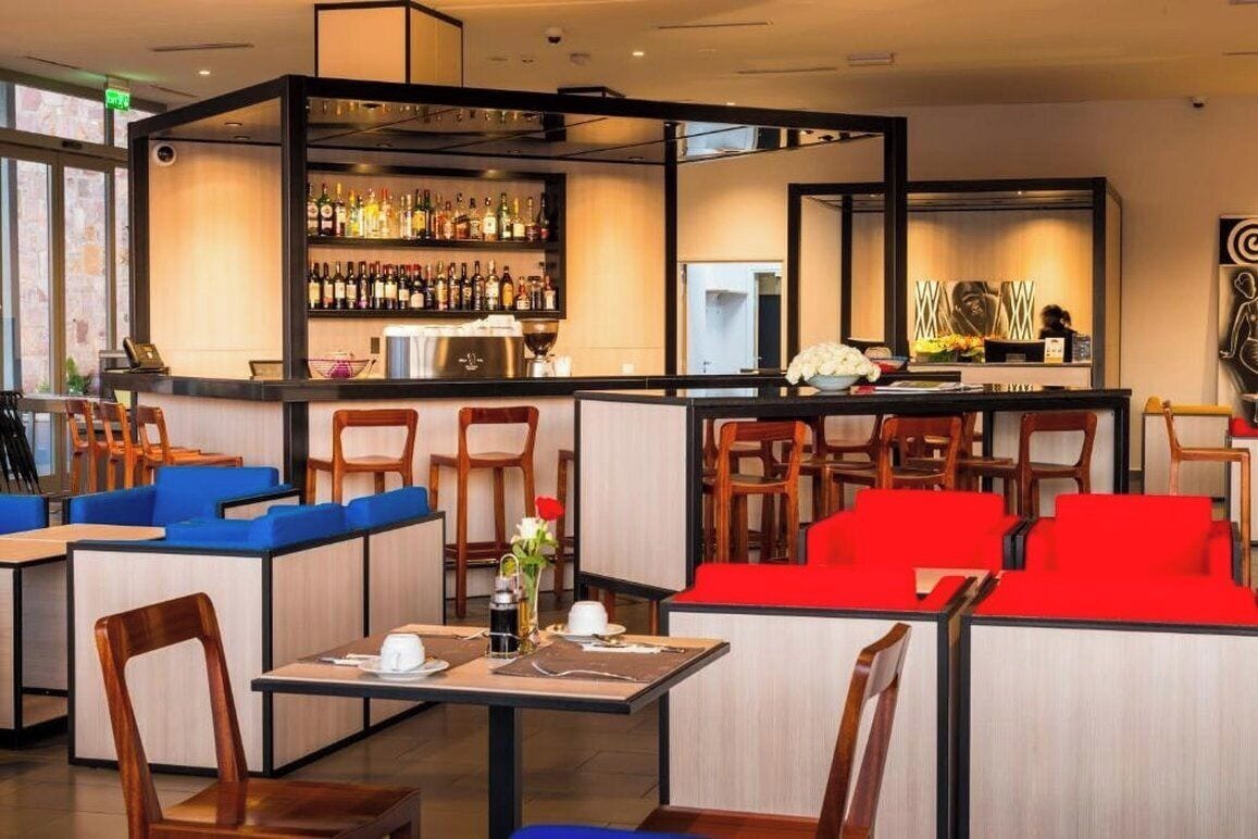 Un restaurant doté d’un bar, d’un espace pour s’asseoir et d’une vue sur la rue.