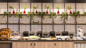 A buffet setup with various food items and a coffee station. - ONOMO Hotel Durban (Durban)