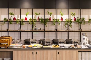 Ein reichhaltiges Buffet mit verschiedenen Speisen und einer Kaffeestation.