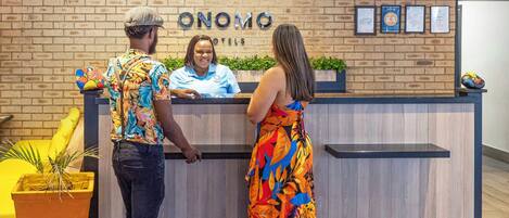 A reception desk with a sign that reads 'ONOMO HOTELS'.