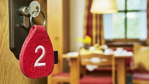 Un porte-clés rouge avec le numéro 2, fixé à une serrure de porte.