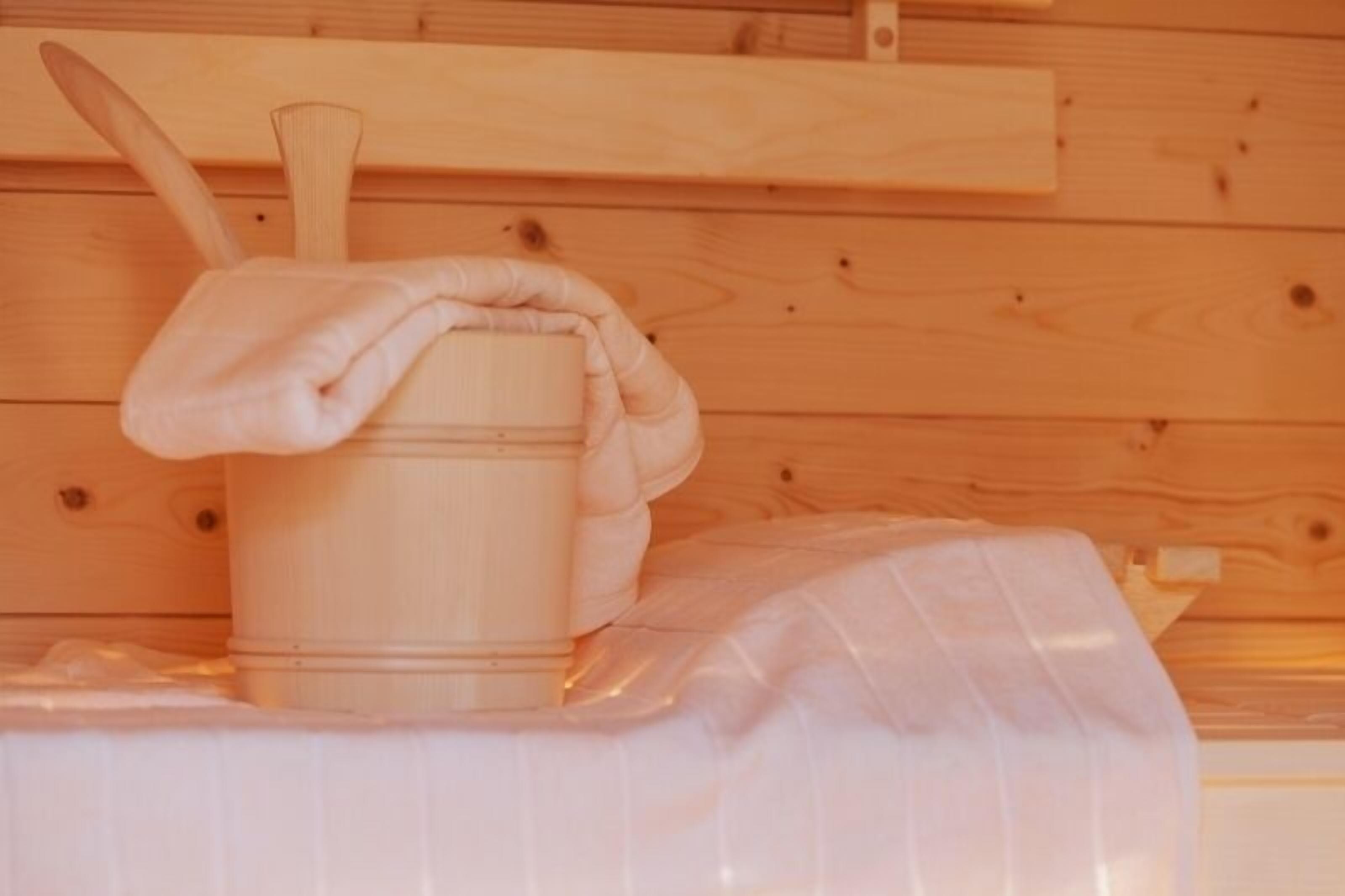 A wooden sauna with a wooden bucket and a wooden ladle.