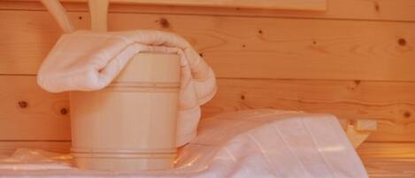 A wooden sauna with a wooden bucket and a wooden ladle.