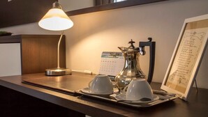 Un comptoir d’accueil d’hôtel avec une lampe, une cafetière et un menu encadré.