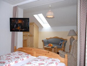 A bedroom with a bed, a sofa, a television, and a skylight. - 5. Fewo Kampenwand, 28 qm, 1-2 Pers., Wohn-Schlafraum, Westbalkon 2. OG (Grassau)