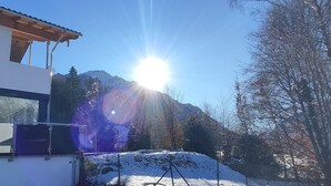 Un edificio moderno con ventanas amplias, una cerca metálica y suelo cubierto de nieve.