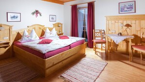 Une chambre confortable avec un lit en bois, un bureau et une chaise.