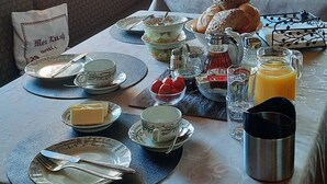 Una colazione servita su un tavolo, con piatti, posate e diversi tipi di cibo.