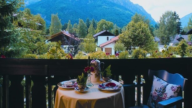 A table set for dining with a mountain view in the background. - Stylish apartment with mountain view (St2)/Steilhofweg. 50 sqm, 1 bedroom (Bayerisch Gmain)
