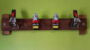 A wooden rack with four shoehorns mounted on it.