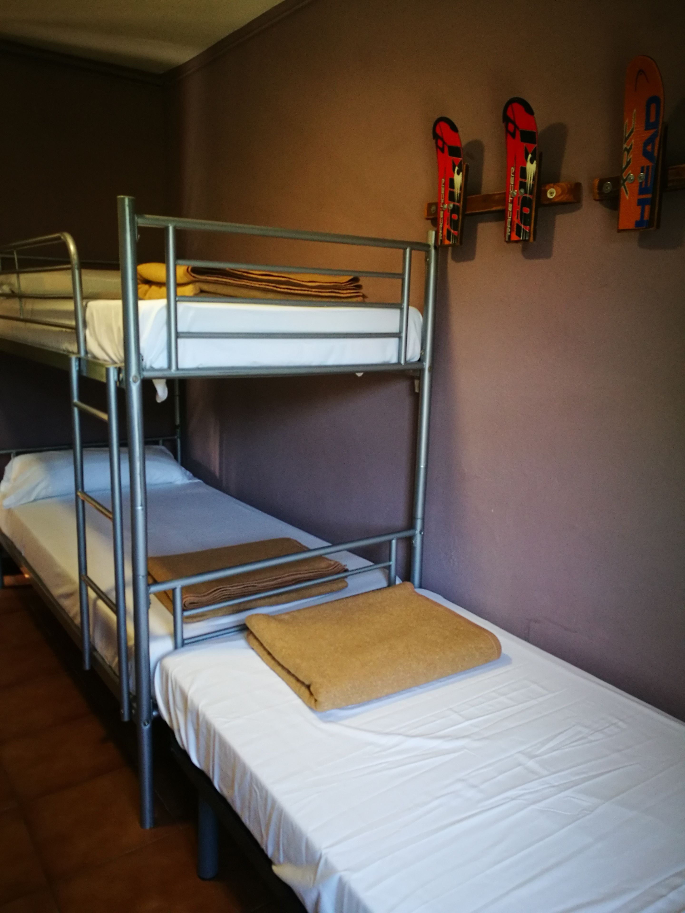 Une chambre avec un lit superposé et une paire de skis accrochés au mur.