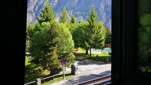 A view of a mountainous landscape through a window, with a road and a no parking sign visible. - Alberg Les Daines (Espot)