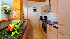 Una cocina moderna con armarios de madera, estufa de acero inoxidable y salpicadero de azulejos.