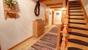 A wooden staircase with a handrail, a wooden bench, and a wall-mounted mirror. - Cozy vacation apartment 3, 25 sqm (Schneizlreuth)