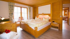 Une chambre à coucher en bois, avec un lit, des tables de chevet et une fenêtre avec des rideaux.