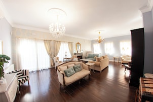Un salón amplio con sofá, sillones, una mesa de centro y chimenea.