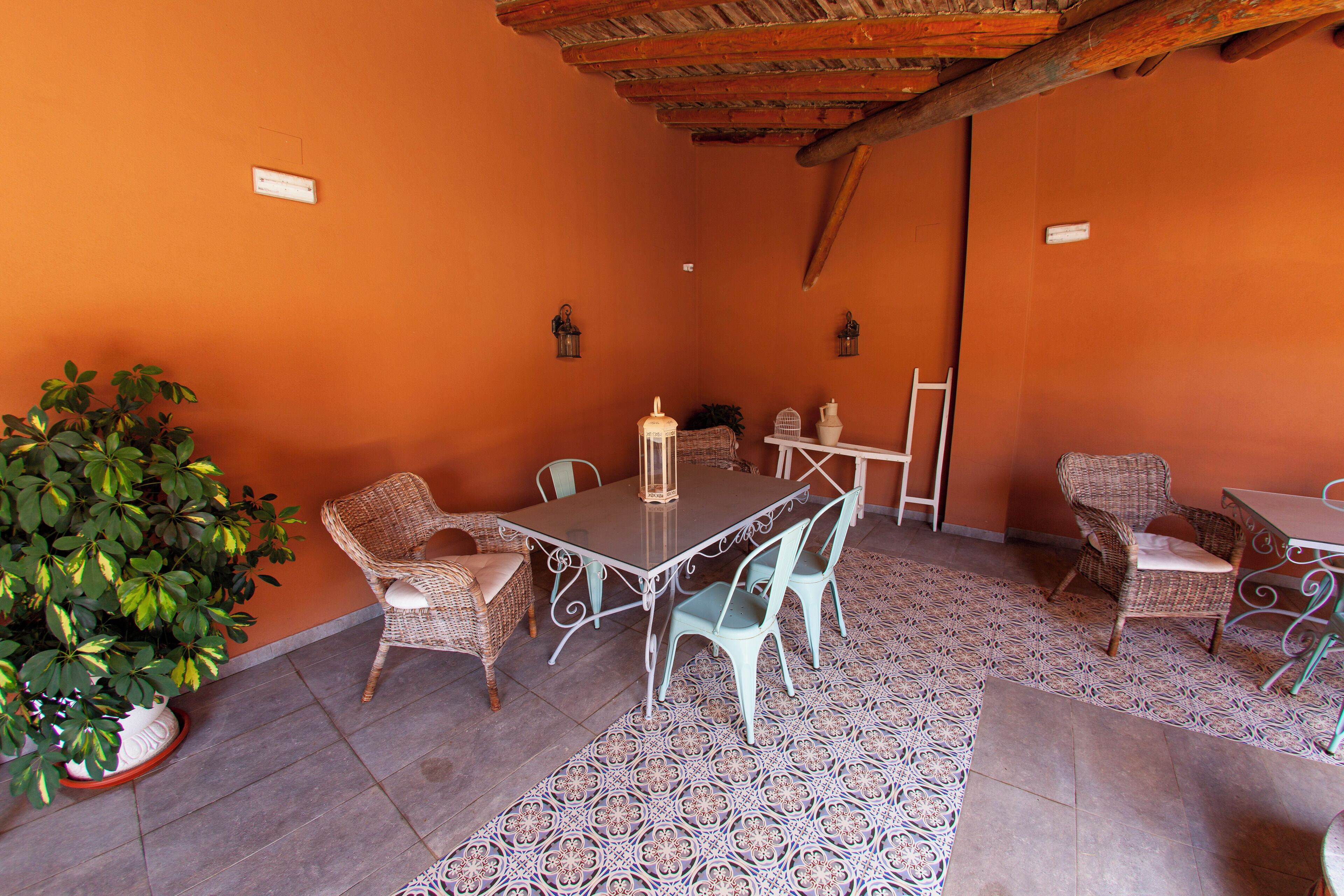 A patio with a table and chairs, potted plants, and decorative lanterns.