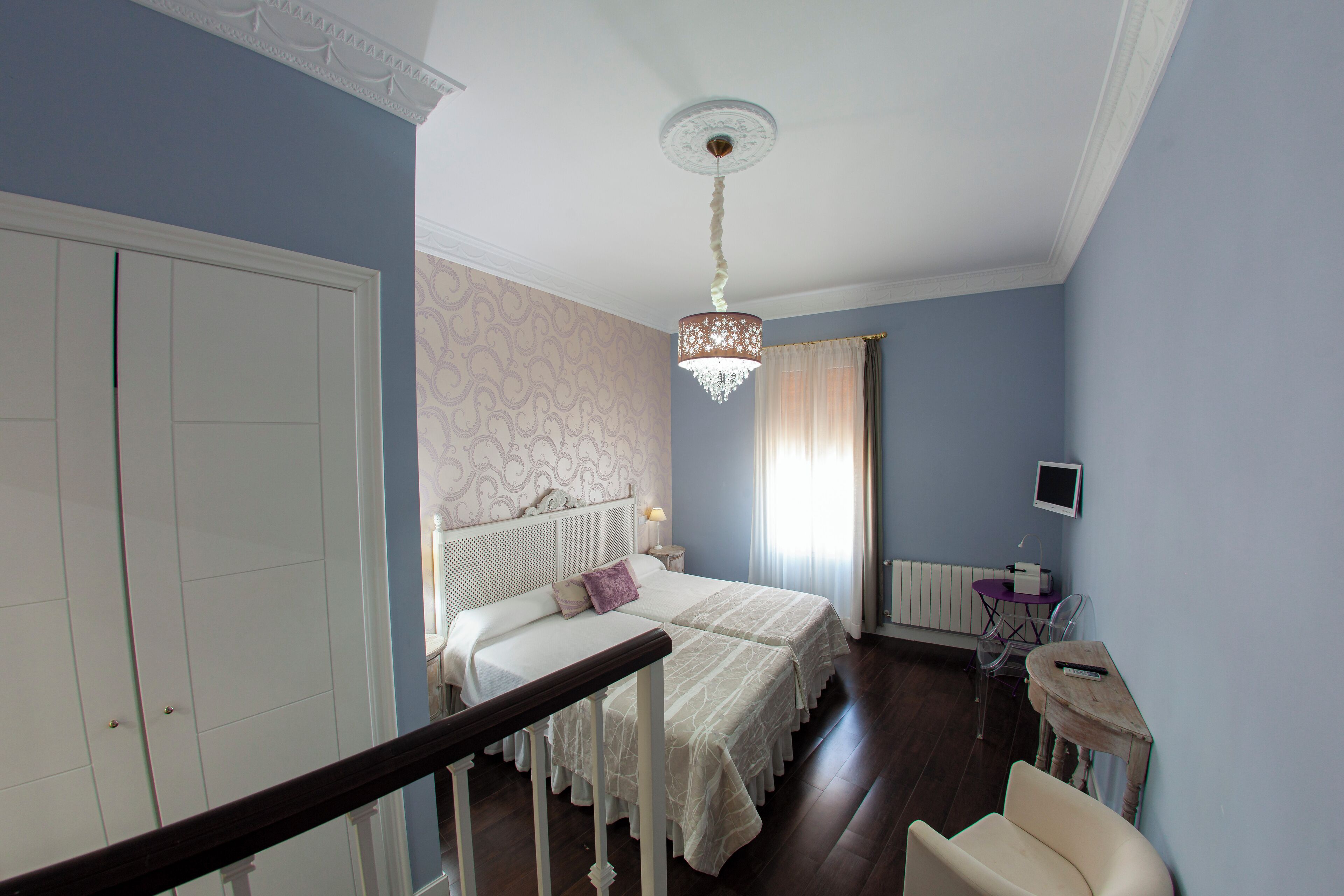 Une chambre à coucher avec un lit double, une table de chevet, un bureau et une chaise.