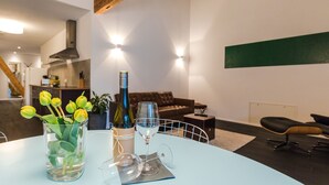 Ein modernes Wohnzimmer mit rundem Tisch, einer Couch und einem Essbereich.