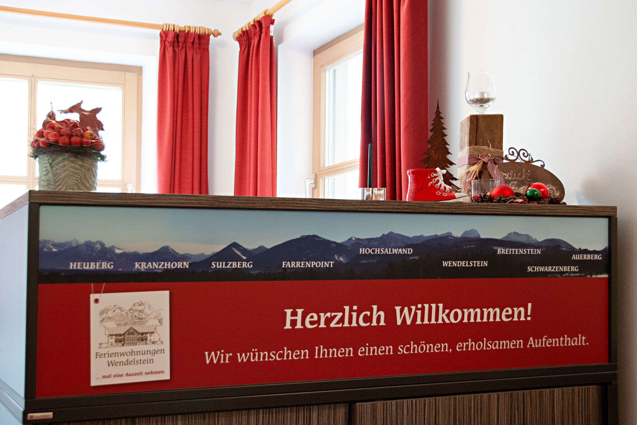 A reception desk with a welcome sign, a framed map of the region, and a decorative item on top.