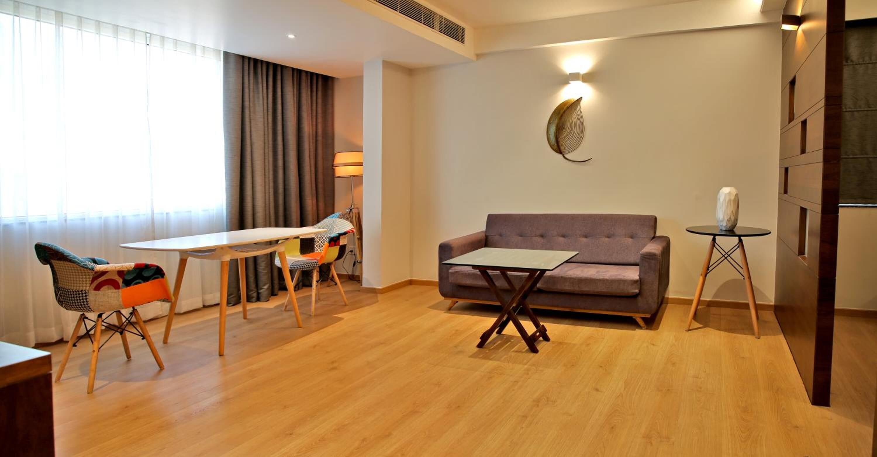 A modern living room with a sofa, a small table, a chair, and a lamp.