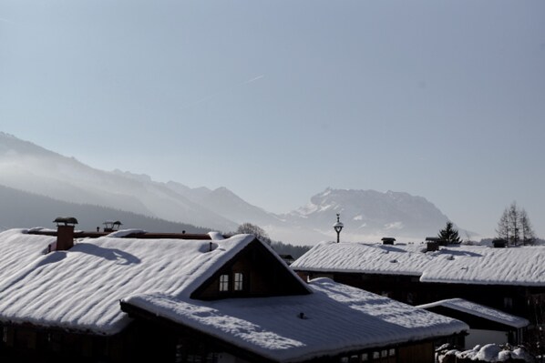 Un villaggio innevato con case in legno tradizionali e una montagna sullo sfondo.
