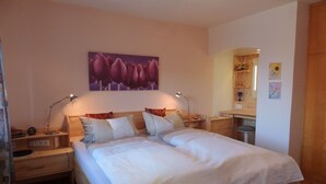 Een slaapkamer met een houten bed, twee nachtkastjes, een wandplank en een spiegel.