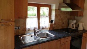 Una cocina con armarios de madera, un lavamanos doble y una estufa.
