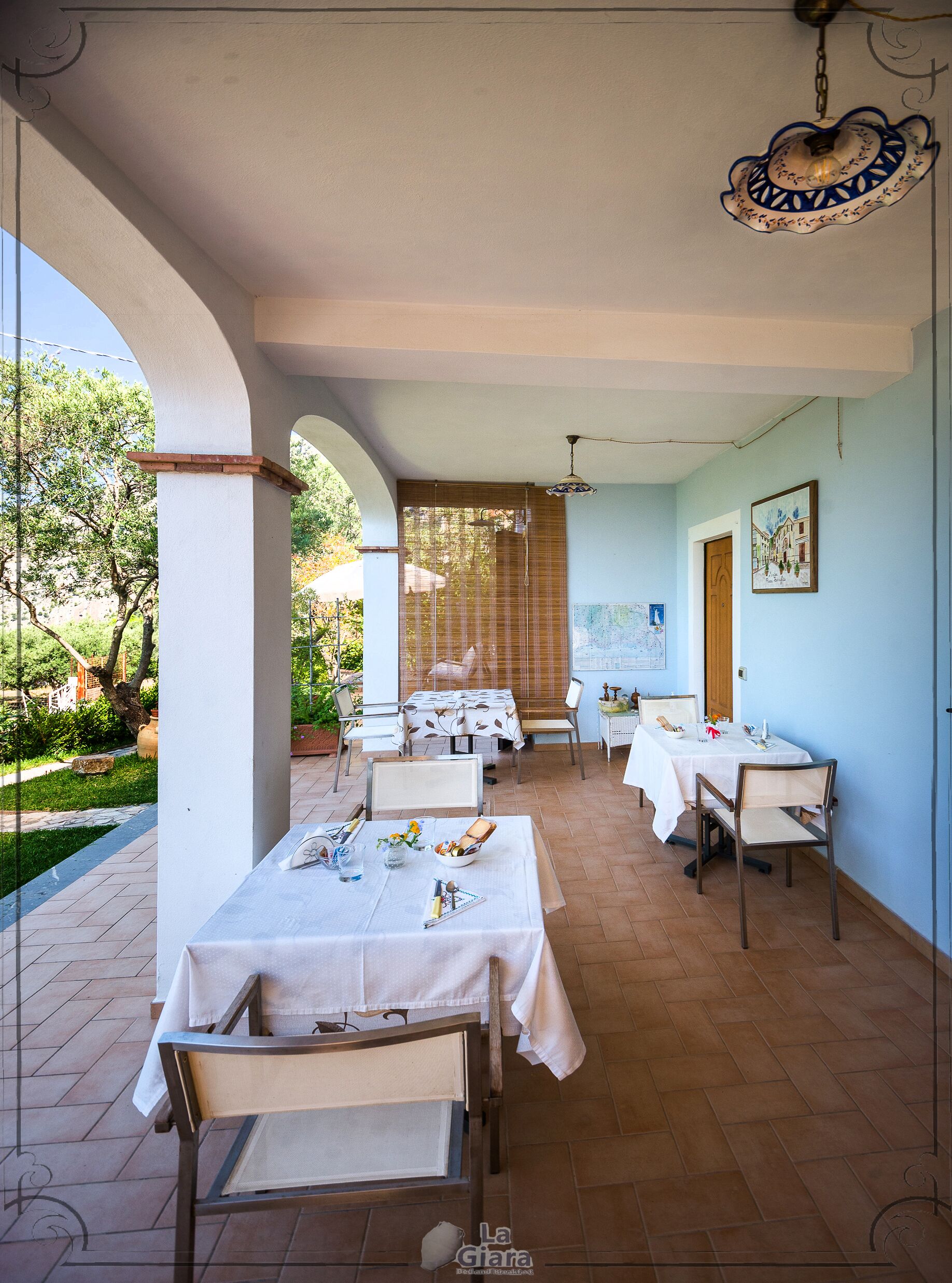 A dining area with multiple tables and chairs, a ceiling fan, and a view of the outdoors.