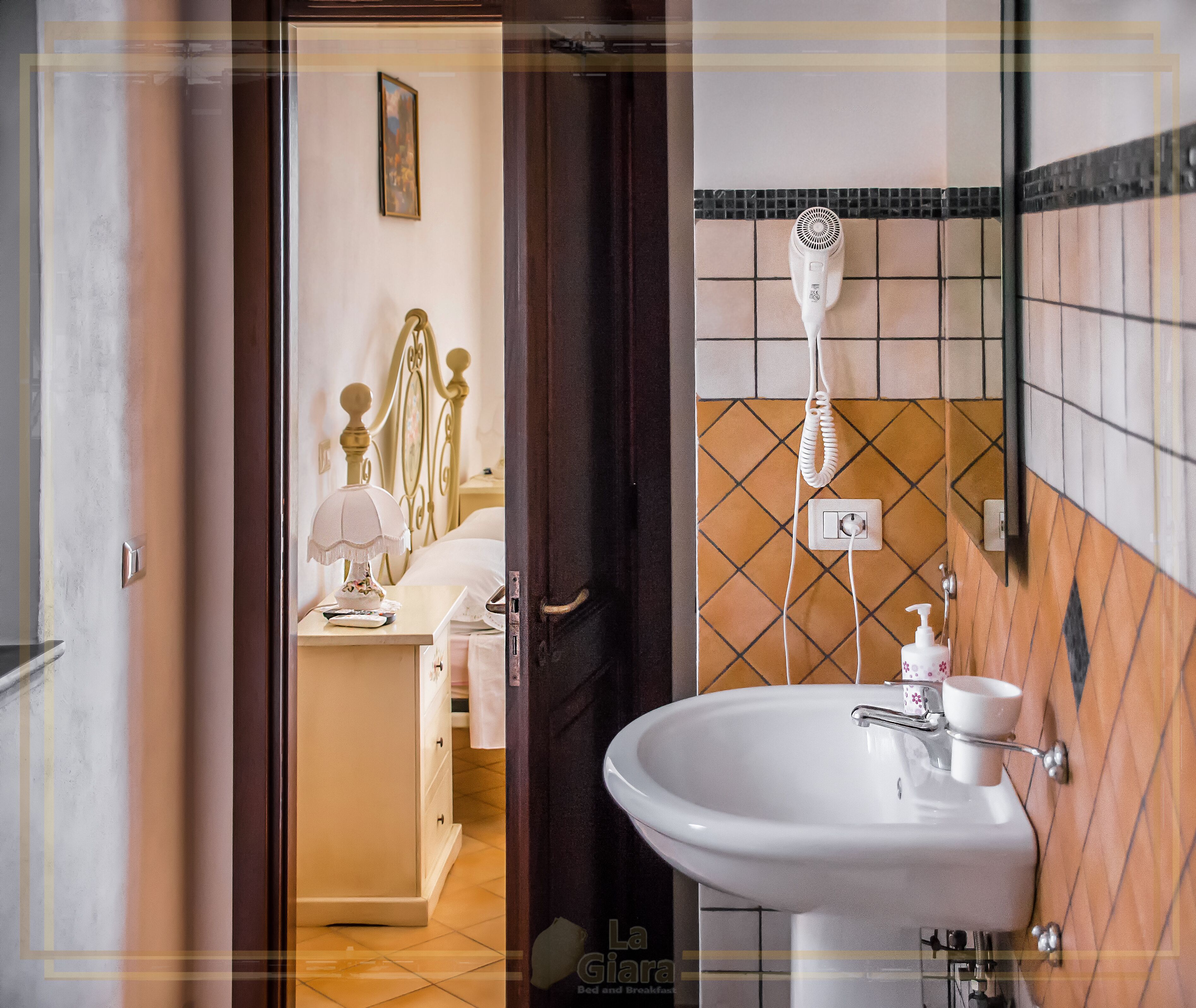 A bathroom with a sink, mirror, and towel rack.