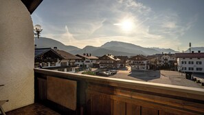 A mountain town with traditional architecture, a clear sky, and a view of the mountains.