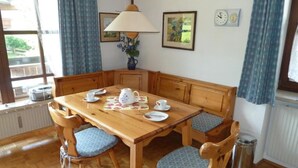 Ein Esszimmer mit Holztisch und Stühlen, einer Lampe und einer Wanduhr.