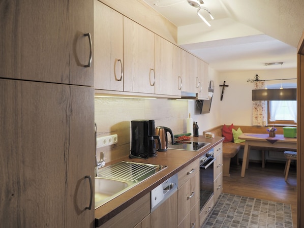 A modern kitchen with wooden cabinets, a stainless steel sink, and a built-in oven.
