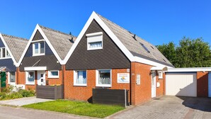 A row of modern, two-story houses with a uniform architectural style, featuring pitched roofs and brick exteriors. - Holiday house beach pearl (Esens)