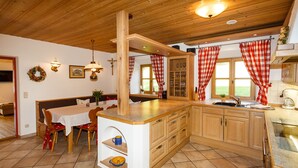A kitchen with wooden cabinets, a dining table with chairs, and a large island with a sink.