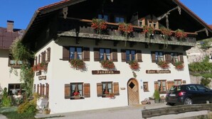 A traditional Alpine-style building with a sloped roof, wooden shutters, and flower boxes.