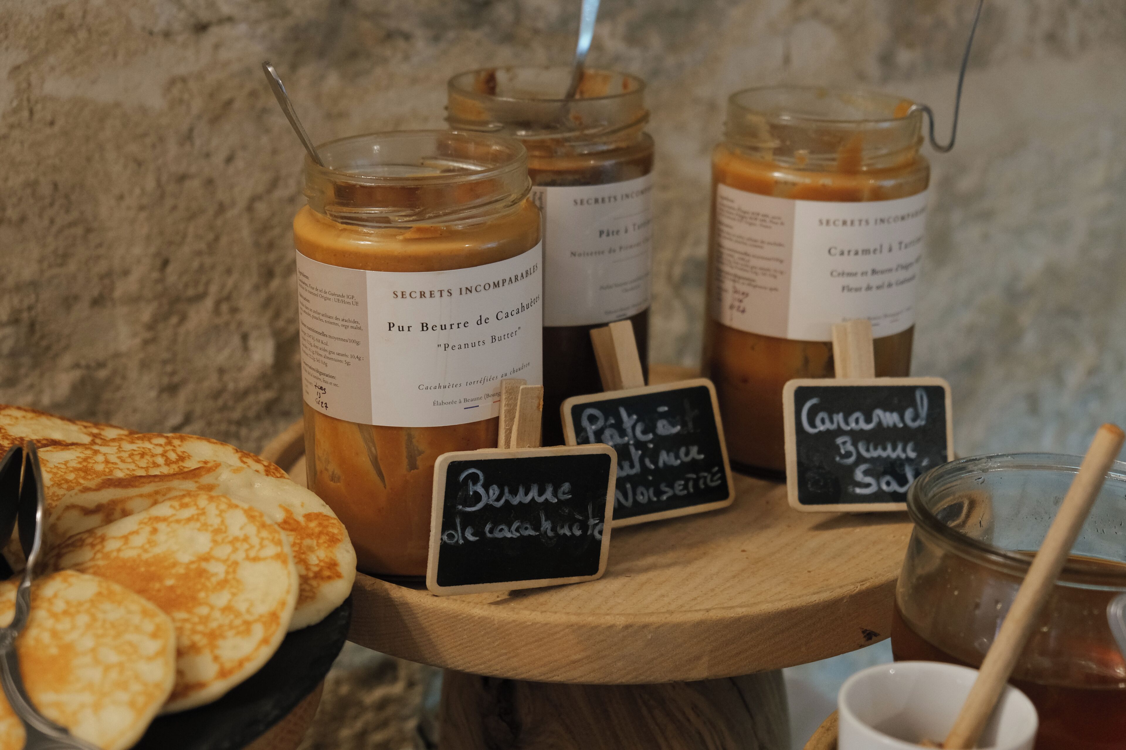 A selection of food items including jars labeled 'Peanuts Butter' and 'Caramel & Tart,' along with a sign indicating 'Pâté de Cerise.'