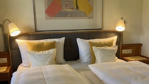 A hotel room with a large bed, two bedside lamps, and a framed artwork on the wall. - (3) One-room apartment, approx. 25 m², kitchenette and balcony (Reit im Winkl)