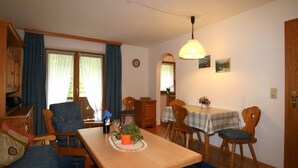 Un'accogliente zona pranzo con un tavolo di legno, sedie e un lampadario.
