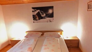 Un dormitorio con una cama, dos mesitas de noche y una mesita auxiliar.