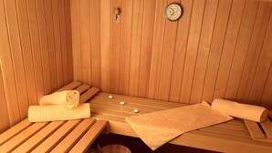 A sauna room with wooden benches, towels, and a wooden bucket. - Drei-Raum-Ferienwohnung (7) Unterberg, 82 qm, Bad/WC, Extra-Schlafzimmer, Küche, Balkon (Reit im Winkl)