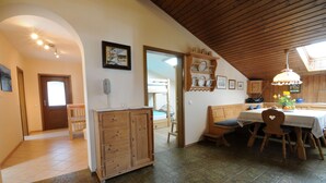 Una cocina con armarios de madera, una mesa de comedor con sillas y un ventilador de techo.